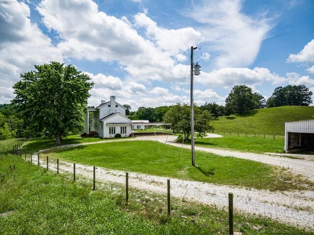 view of yard with gravel driveway and a rural view