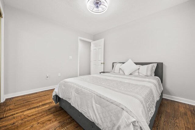 bedroom with dark wood-style floors and baseboards