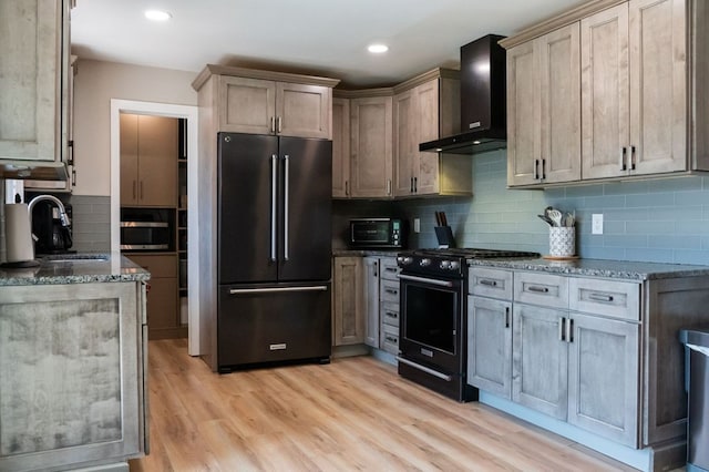 5414 Doubleview Cir, Baxter, TN 38544 - kitchen featuring freestanding refrigerator, wall chimney range hood, black gas range oven, dark stone countertops, and decorative backsplash