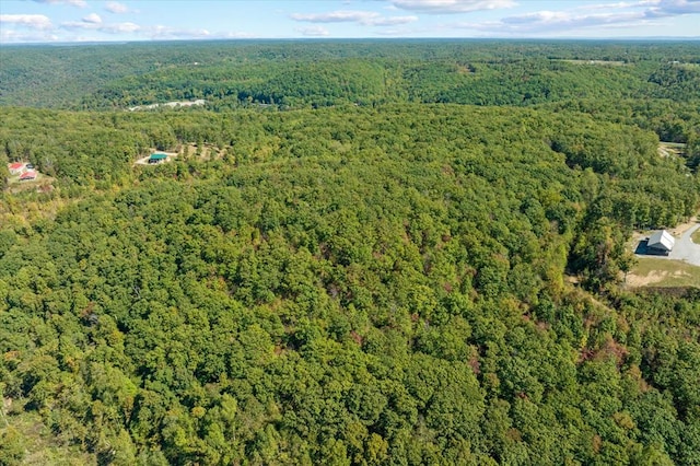 drone / aerial view featuring a wooded view