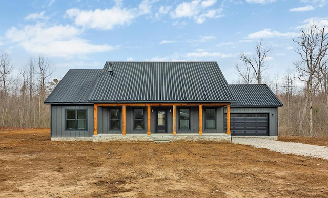 exterior space featuring a garage, driveway, metal roof, and board and batten siding