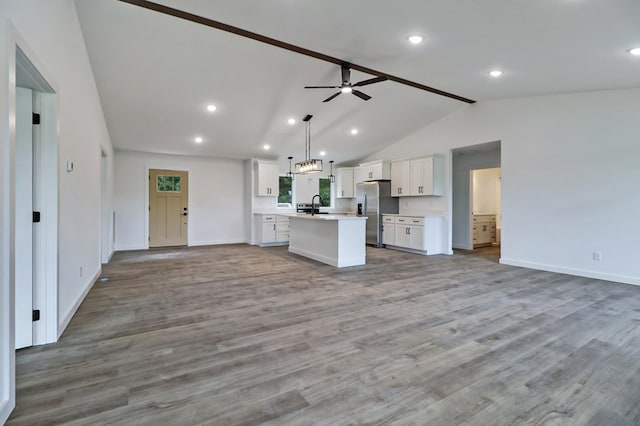 819 Hack Beaty Rd, Grimsley, TN 38565 - kitchen with open floor plan, stainless steel fridge, white cabinets, light countertops, and an island with sink