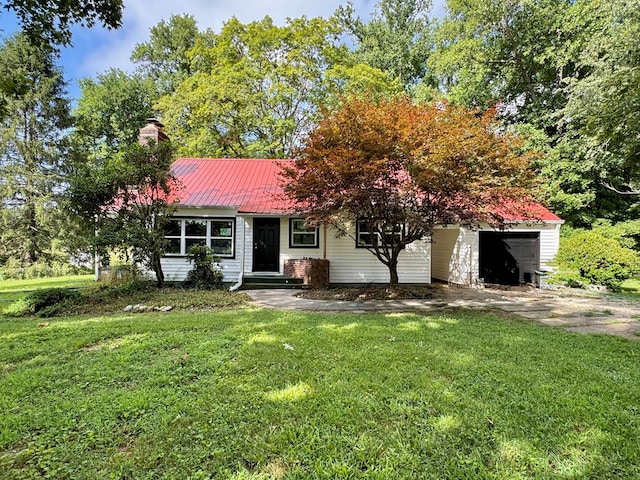 46326 US-127 S, Pikeville, TN 37367 - view of front of house with a front lawn, a chimney, a metal roof, and a garage