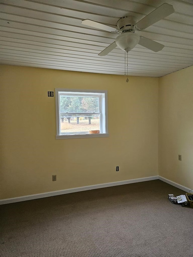 carpeted spare room with a ceiling fan and baseboards