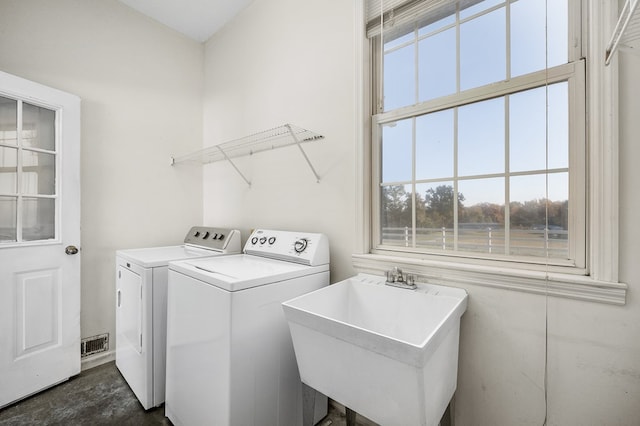 clothes washing area featuring laundry area, washer and clothes dryer, a sink, and visible vents