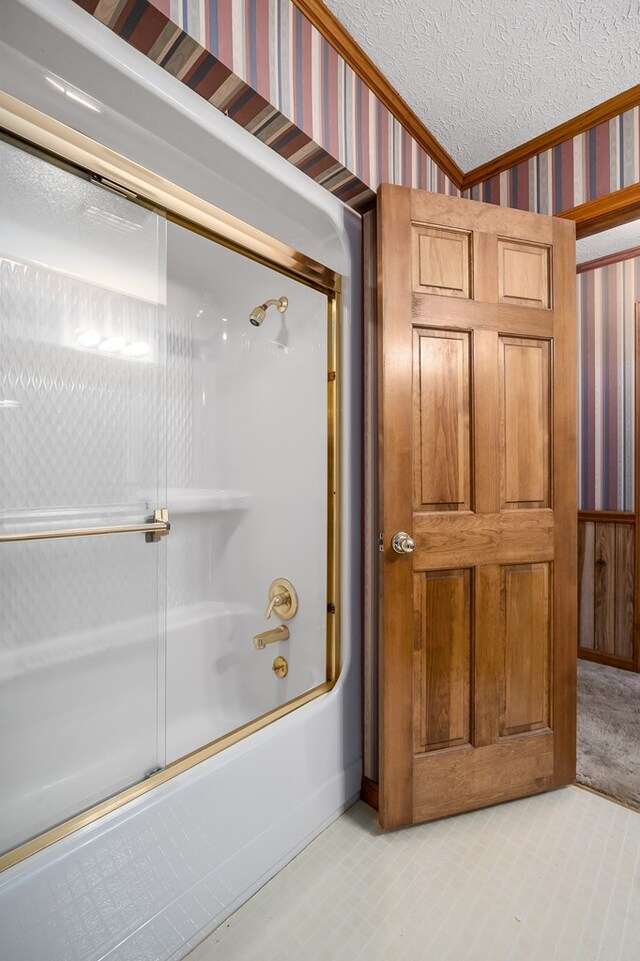 full bathroom with enclosed tub / shower combo, crown molding, a textured ceiling, and wallpapered walls