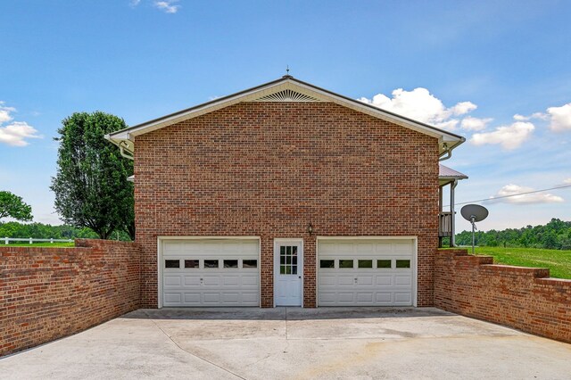 view of property exterior with a detached garage and brick siding