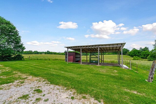 view of yard with an outdoor structure, an outbuilding, a carport, and a rural view