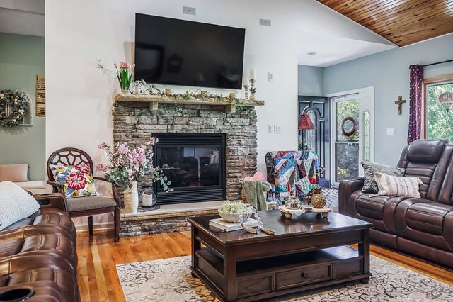 living room with wooden ceiling, light wood-style flooring, a fireplace, and vaulted ceiling