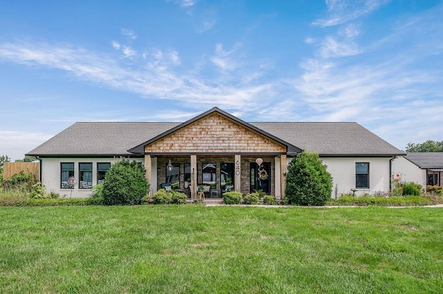 view of front of property with a shingled roof and a front lawn