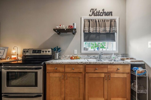 kitchen with brown cabinets, electric stove, light countertops, and a sink