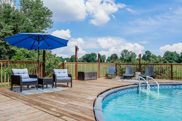 view of swimming pool featuring outdoor lounge area, a deck, and a fenced in pool