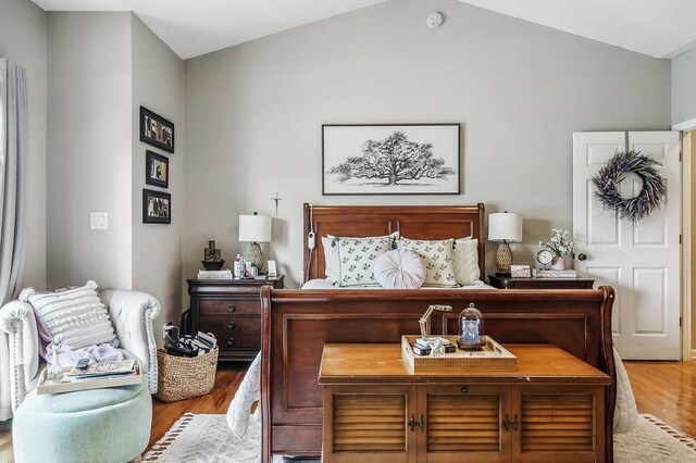 bedroom with vaulted ceiling and wood finished floors