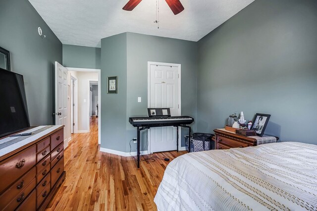 bedroom with light wood-style floors, ceiling fan, and baseboards