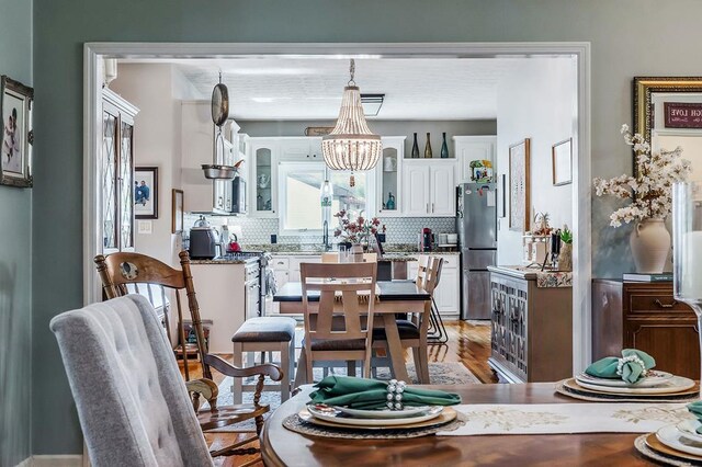 dining space with a chandelier and wood finished floors