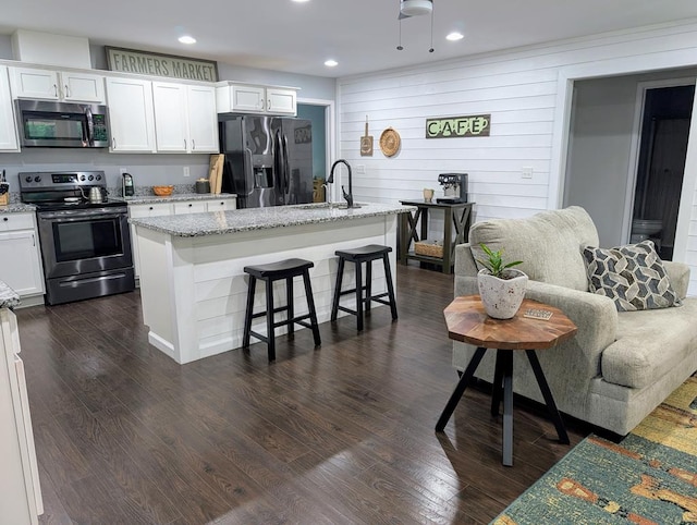 3569 Dry Mill Creek Rd, Hilham, TN 38568 - kitchen with stainless steel appliances, white cabinetry, an island with sink, light stone countertops, and recessed lighting