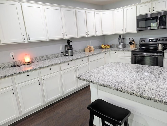 3569 Dry Mill Creek Rd, Hilham, TN 38568 - kitchen with appliances with stainless steel finishes, white cabinets, dark wood finished floors, and light stone counters