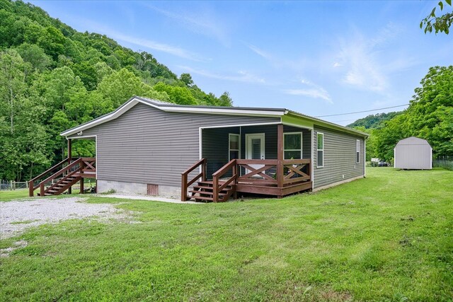 3569 Dry Mill Creek Rd, Hilham, TN 38568 - back of property featuring crawl space, stairs, a lawn, a deck, and a storage unit