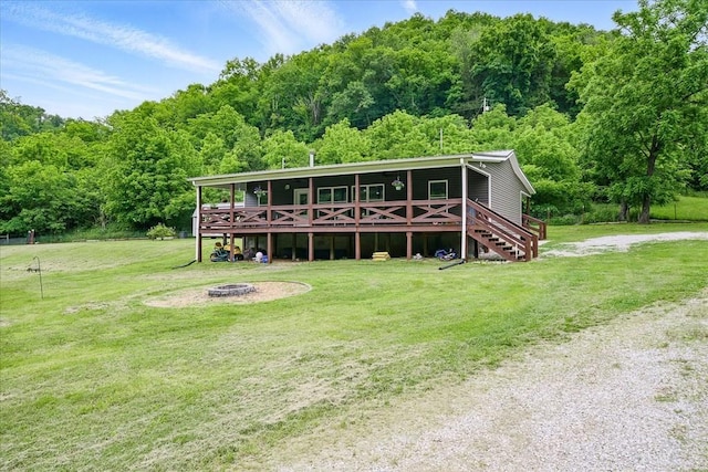 3569 Dry Mill Creek Rd, Hilham, TN 38568 - view of front of house with a front lawn, a wooded view, an outdoor fire pit, and a wooden deck