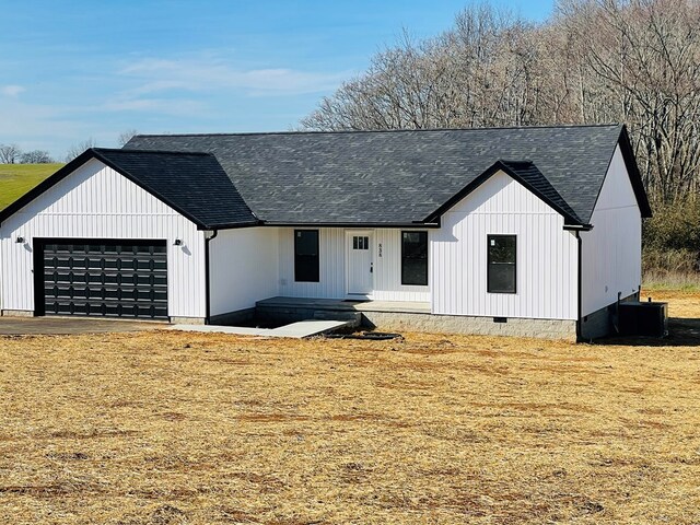 modern inspired farmhouse with crawl space, an attached garage, cooling unit, and a shingled roof