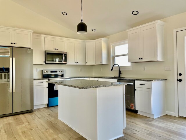 kitchen featuring white cabinetry, stainless steel appliances, a sink, and a center island