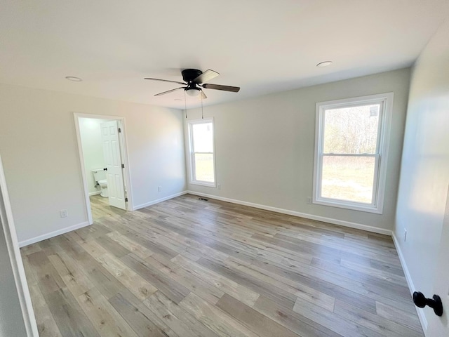 spare room with light wood-style flooring, visible vents, baseboards, and ceiling fan