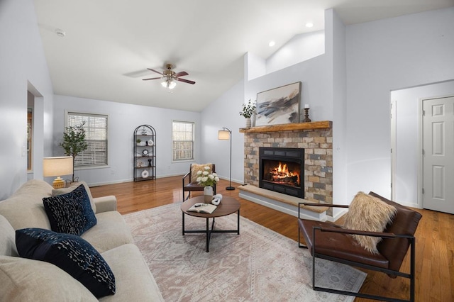 living room featuring a brick fireplace, light wood-style flooring, baseboards, and high vaulted ceiling