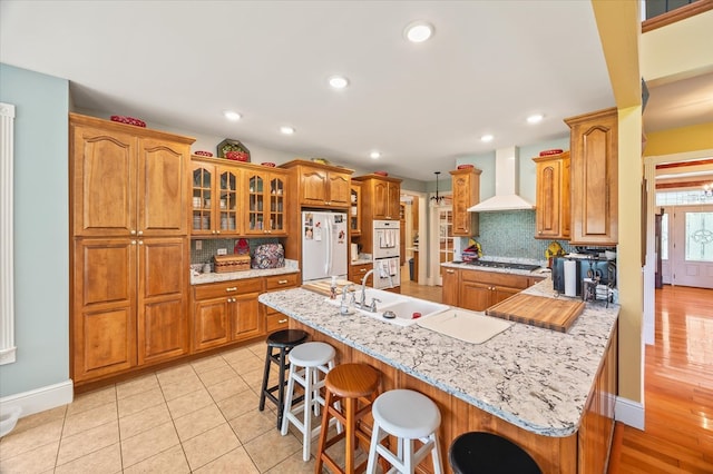 292 Mclerran Cemetery Rd, Moss, TN 38575 - kitchen featuring wall chimney range hood, white appliances, a breakfast bar, brown cabinetry, and recessed lighting