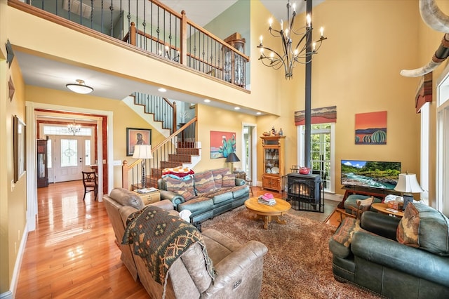 292 Mclerran Cemetery Rd, Moss, TN 38575 - living room featuring a chandelier, stairs, healthy amount of natural light, a wood stove, and a towering ceiling