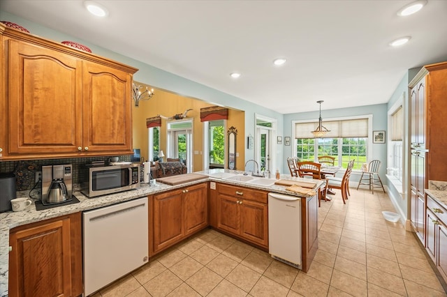 292 Mclerran Cemetery Rd, Moss, TN 38575 - kitchen featuring dishwasher, stainless steel microwave, a peninsula, light tile patterned floors, and brown cabinetry