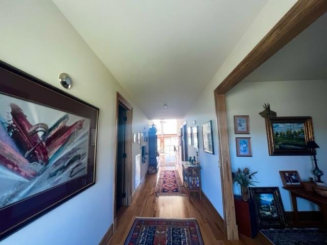 hallway with baseboards and wood finished floors