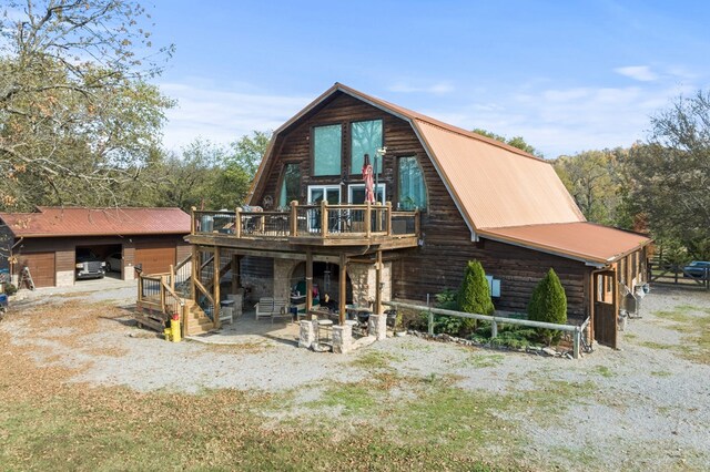 back of house with an outbuilding and a gambrel roof