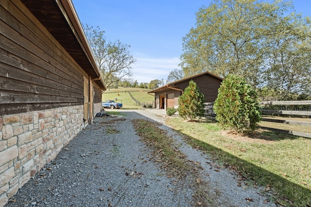 view of side of home with driveway and fence