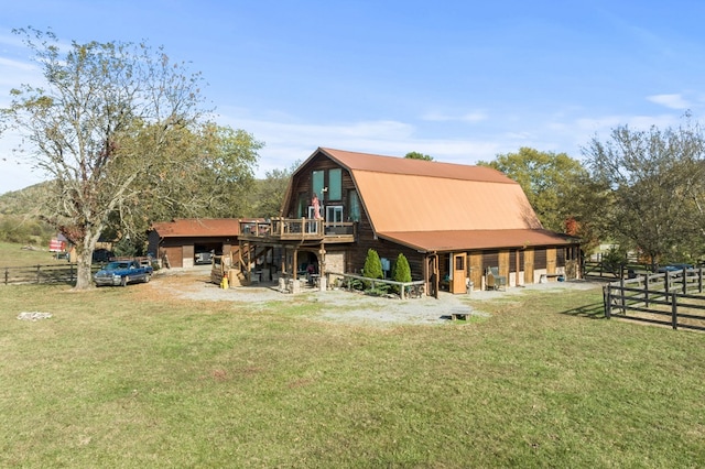 rear view of property featuring a yard, fence, and a gambrel roof