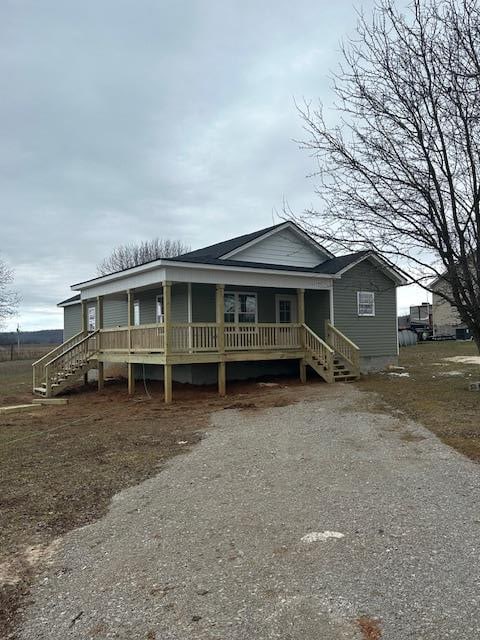 view of front of house with driveway, crawl space, and stairs