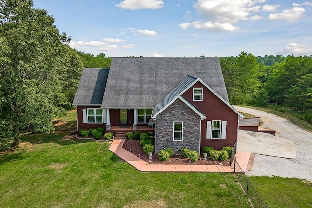 view of front of home featuring stone siding, a front lawn, and roof with shingles