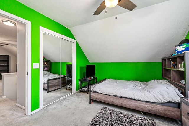 bedroom featuring lofted ceiling, a closet, light carpet, and baseboards