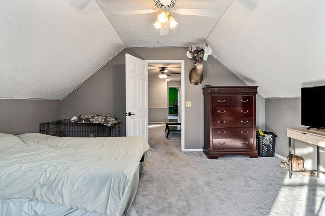 bedroom featuring ceiling fan, baseboards, vaulted ceiling, and light colored carpet