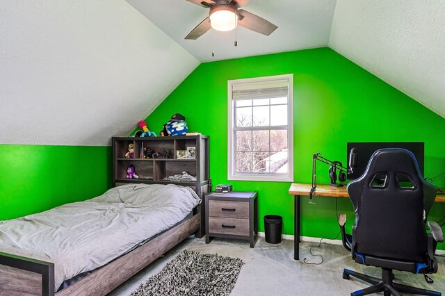 bedroom featuring a textured ceiling, light carpet, a ceiling fan, baseboards, and vaulted ceiling