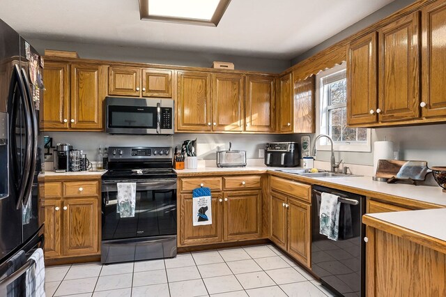 kitchen featuring brown cabinets, light countertops, and black appliances