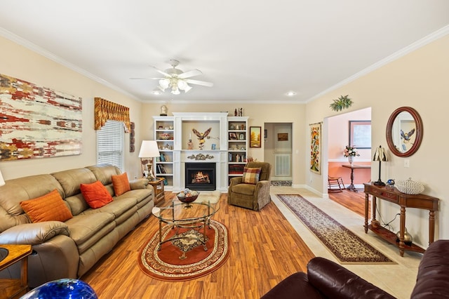 169 Prosperity Dr, Baxter, TN 38544 - living area with ornamental molding, wood finished floors, a ceiling fan, a warm lit fireplace, and baseboards
