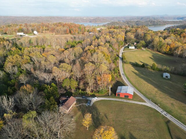 drone / aerial view featuring a water view and a wooded view