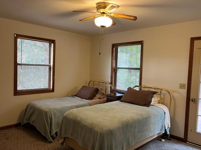 carpeted bedroom featuring ceiling fan and baseboards