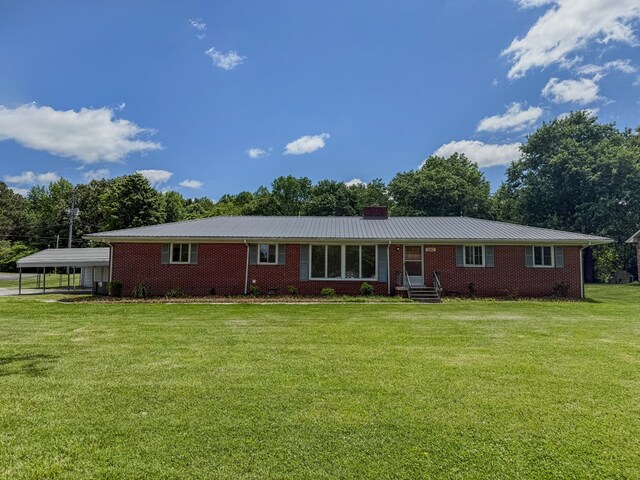 540 4th Ave, Baxter, TN 38544 - view of front of house featuring entry steps, a front lawn, a detached carport, brick siding, and a chimney