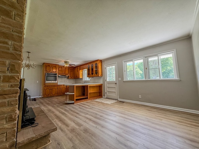 540 4th Ave, Baxter, TN 38544 - kitchen featuring brown cabinets, oven, glass insert cabinets, light wood-type flooring, and crown molding