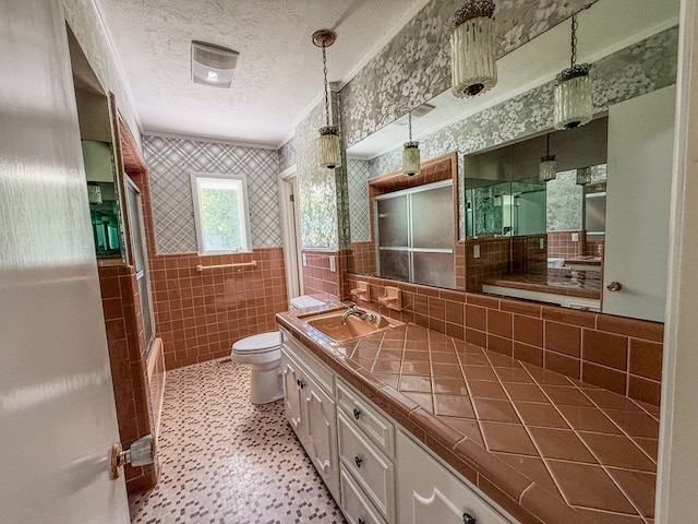 540 4th Ave, Baxter, TN 38544 - bathroom featuring wallpapered walls, tile walls, a textured ceiling, wainscoting, and vanity