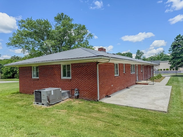 540 4th Ave, Baxter, TN 38544 - view of home's exterior with a patio area, a yard, brick siding, a chimney, and a metal roof
