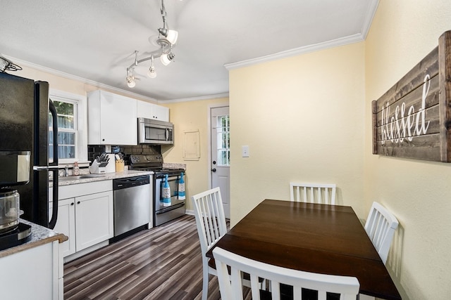 kitchen with white cabinets, decorative backsplash, dark wood-style flooring, stainless steel appliances, and crown molding