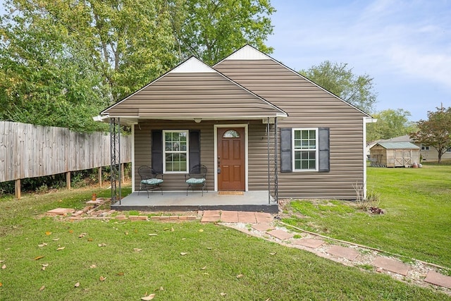 bungalow featuring fence and a front lawn