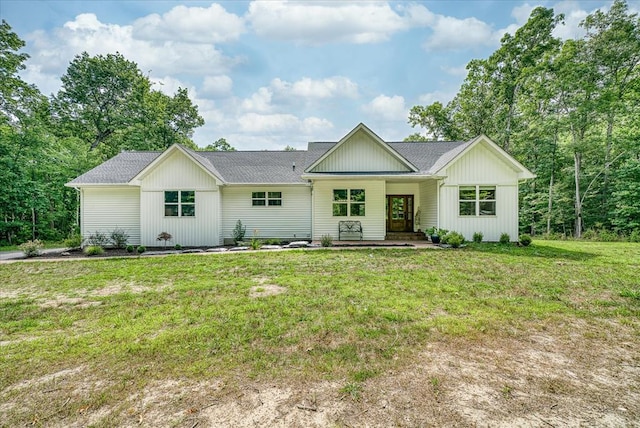 view of front facade featuring roof with shingles and a front lawn